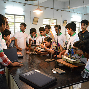 Students working on practical physics experiments using laboratory equipment at KBN College